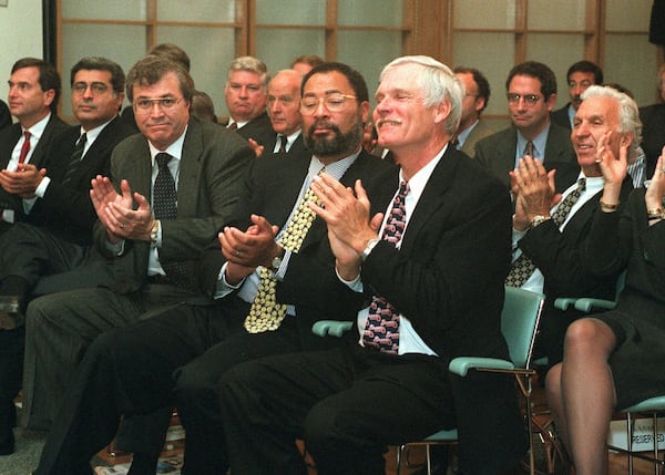 FILE - Turner Broadcasting Systems Chairman & CEO Ted Turner, right foreground, and Richard Parsons, Time Warner president, to Turner's right, applaud the outcome of the Time Warner shareholders' vote, in New York, Thursday, Oct. 10, 1996. (AP Photo/Marty Lederhandler, File)