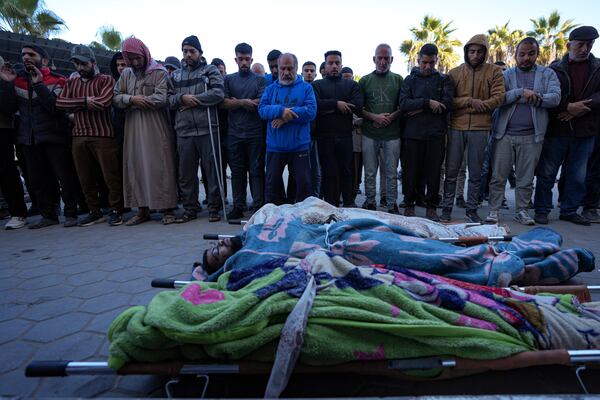 Palestinians pray next to the bodies of their relatives killed in the Israeli bombardment of the Gaza Strip at Al-Aqsa Hospital in Deir al-Balah, Thursday, Dec. 19, 2024. (AP Photo/Abdel Kareem Hana)