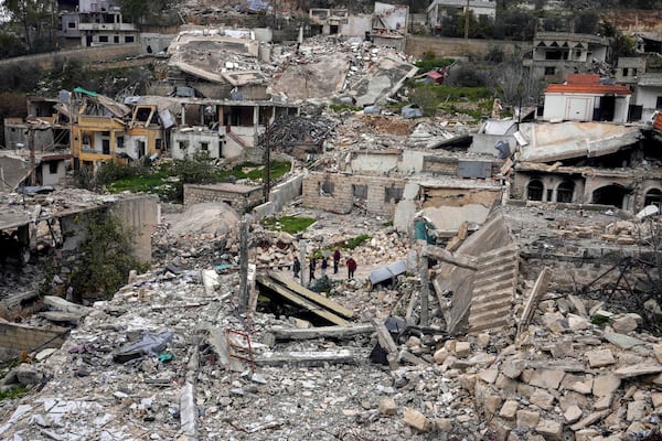 Lebanese citizens check the destruction in their village caused by the Israeli air and ground offensive, in the town of Odaisseh, southern Lebanon, Wednesday, Feb. 19, 2025. (AP Photo/Hassan Ammar)