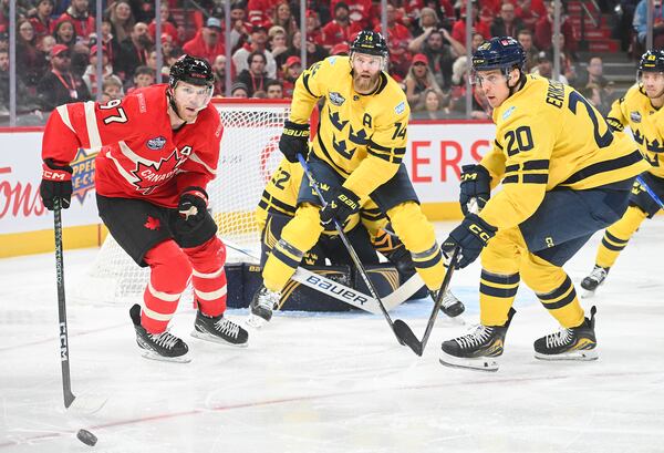 Canada's Connor McDavid (97) and Sweden goaltender Filip Gustavsson, Mattias Ekholm (14) and Joel Eriksson Ek (20) watch the puck during the first period of 4 Nations Face-Off hockey action in Montreal, Wednesday, Feb. 12, 2025. (Graham Hughes/The Canadian Press via AP)