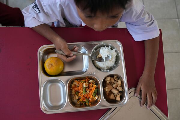 A student has his meal during the kick off of President Prabowo Subianto's ambitious free meal program to feed children and pregnant women nationwide despite critics saying that its required logistics could hurt Indonesia's state finances and economy, at an elementary school in Depok, West Java, Indonesia, Monday, Jan. 6, 2025. (AP Photo/Dita Alangkara)