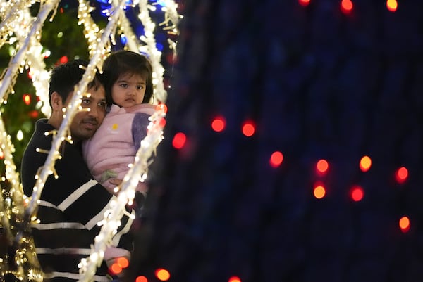 A family looks at the Lights of Joy display Monday, Dec. 16, 2024, in Kennesaw, Ga. (AP Photo/Brynn Anderson)