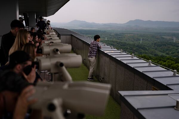 FILE - Tourists use binoculars to view North Korea from the Dora Observation Post in the Demilitarized Zone (DMZ) in Paju, South Korea, Saturday, May 25, 2024. (AP Photo/Jae C. Hong, File)