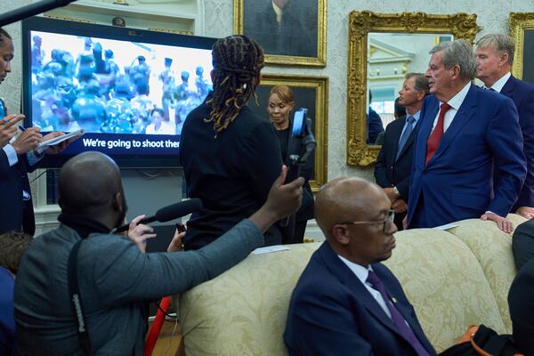 South African businessman Johann Rupert, standing right, watches a video during a meeting between President Donald Trump and South African President Cyril Ramaphosa in the Oval Office of the White House, Wednesday, May 21, 2025, in Washington. (AP Photo/Evan Vucci)