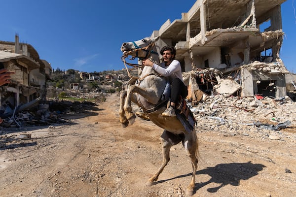 A Lebanese man rides his horse in a village destroyed by an Israeli air and ground offensive, in the town of Kfar Kila, southern Lebanon, Tuesday, Feb. 18, 2025. (AP Photo/Hassan Ammar)