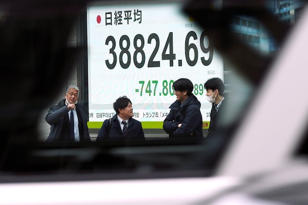 An electronic stock board showing Japan's Nikkei index at a securities firm is seen through the window of a vehicle Monday, Feb. 3, 2025, in Tokyo. (AP Photo/Eugene Hoshiko)