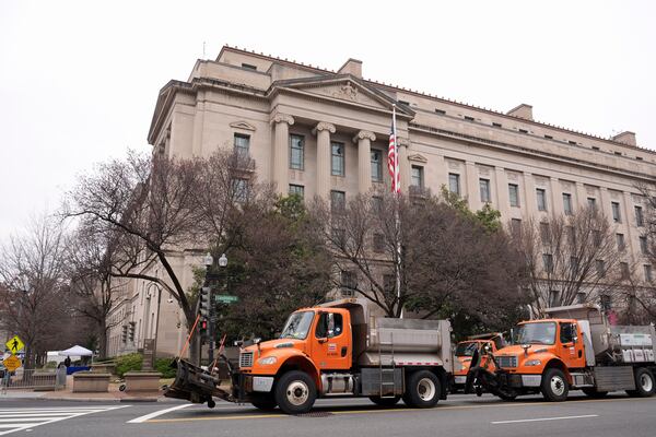 Trucks providing a security barrier are in place around the Department of Justice before President Donald Trump speaks Friday, March 14, 2025, in Washington. (AP Photo/Jacquelyn Martin)