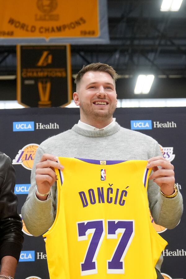 Los Angeles Lakers' Luka Doncic poses for photos with his new jersey during an introductory NBA basketball press conference Tuesday, Feb. 4, 2025, in El Segundo, Calif. (AP Photo/Jae C. Hong)