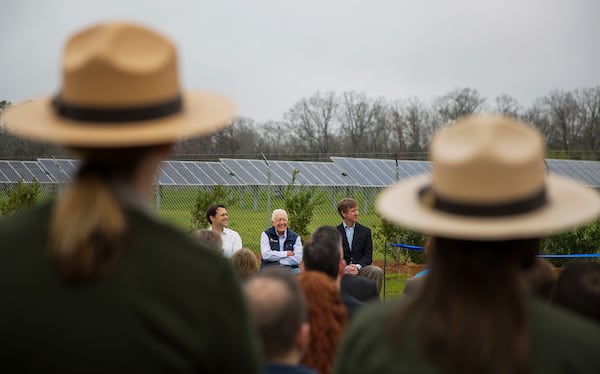 FILE - Former President Jimmy Carter, center, sits with his grandson Jason Carter, left, and George Mori, executive vice president at SolAmerica Energy during a ribbon cutting ceremony for a solar panel project on Jimmy Carter's farmland in his hometown of Plains, Ga., Feb. 8, 2017. (AP Photo/David Goldman, File)