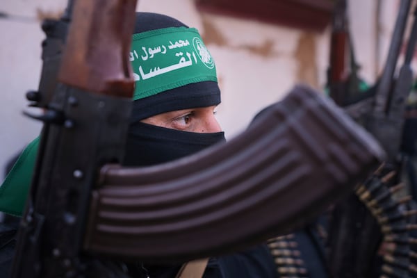 A member of Islamic Jihad fighter holds his weapon as cars carrying Israeli Gadi Mozes and Arbel Yahoud, who have been held hostages by Hamas in Gaza since October 7, 2023, are escorted to be handed over to the Red Cross in Khan Younis, southern Gaza Strip, Thursday Jan. 30, 2025.(AP Photo/Abdel Kareem Hana)