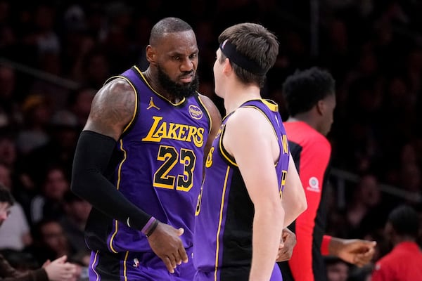 Los Angeles Lakers forward LeBron James, left, celebrates with guard Austin Reaves after making his 30th point of the game during the second half of an NBA basketball game against the Atlanta Hawks, Friday, Jan. 3, 2025, in Los Angeles. With that shot, James surpassed Michael Jordon for most 30-point regular season games in NBA history. (AP Photo/Mark J. Terrill)