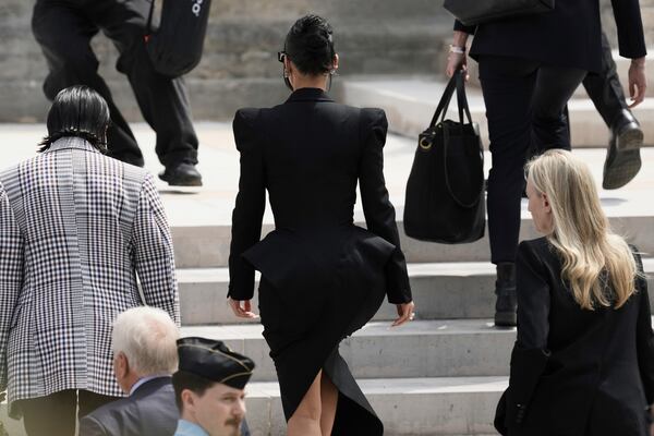 Kim Kardashian, center, walks up the steps of the palace of justice as she arrives to testify regarding a robbery of millions of dollars in jewels from her Paris hotel room in 2016, in Paris, Tuesday, May 13, 2025. (AP Photo/Aurelien Morissard)