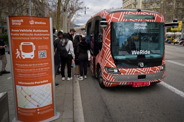 Passengers board a driverless mini-bus, presented by WeRide and Renault Group, in Barcelona downtown, Wednesday, March 12, 2025. (AP Photo/Emilio Morenatti)