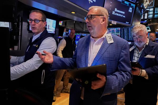 Specialist Glenn Carell, left, and trader Mathias Roberts, center, work on the floor of the New York Stock Exchange, Friday, May 2, 2025. (AP Photo/Richard Drew)