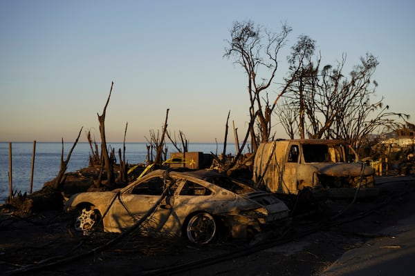 Charred vehicles sit along the coast, Tuesday, Jan. 14, 2025, in Malibu, Calif. (AP Photo/Carolyn Kaster)