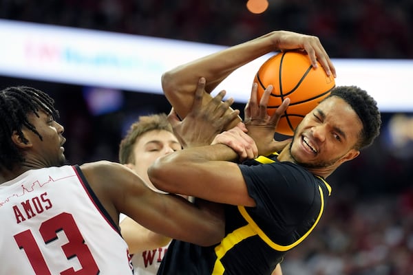 Oregon forward Kwame Evans Jr., right, rebounds the ball against Wisconsin forward Xavier Amos (13) and guard Jack Janicki, back, during the first half of an NCAA college basketball game Saturday, Feb. 22, 2025, in Madison, Wis. (AP Photo/Kayla Wolf)