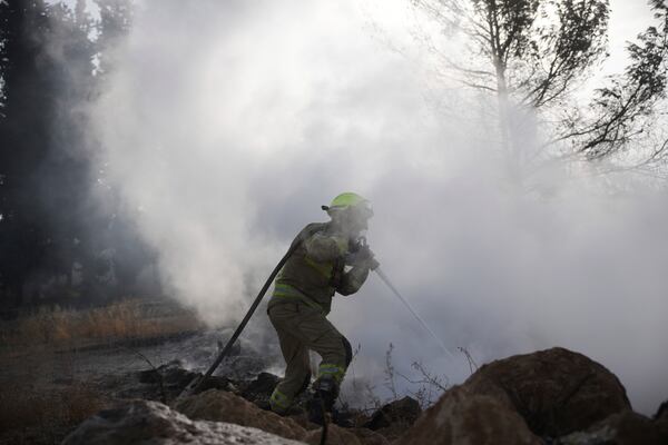 An Israeli firefighter battles a wildfire near Latrun, Israel, outside of Jerusalem, Thursday, May 1, 2025. (AP Photo/Ohad Zwigenberg)