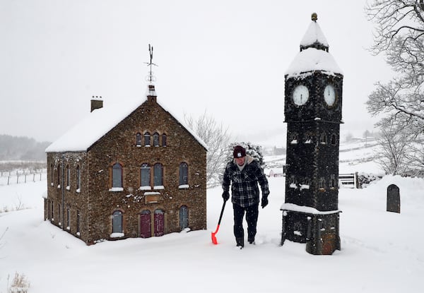 Lowson Robinson is pictured in the heavy snow with his scaled miniature famous landmarks which are located in his garden in Nenthead, England, as the severe weather continues across England, Sunday, Jan. 5, 2025. (AP Photo/Scott Heppell)