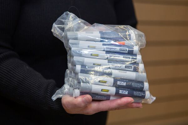 Patient Lory Osborn holds a bag of Wegovy pens used in her treatment at the Medical Weight Management office at West Virginia University in Morgantown, W.Va., Monday, Dec. 2, 2024. (AP Photo/Kathleen Batten)