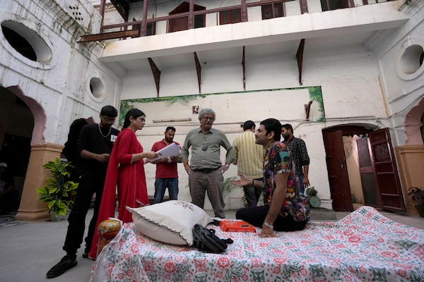 Pakistani tv actor and producer Saife Hassan, center, talks with actor Usman Javed, right, and Sehar Khan, second left, on the set during the shooting of a scene of tv drama serial 'Tan Man Neel-o-Neel' or 'Deeply Engrossed in Love', in Rawalpindi, Pakistan, Saturday, Nov. 2, 2024. (AP Photo/Anjum Naveed)