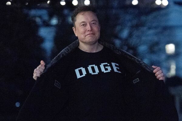 FILE - Elon Musk flashes his T-shirt that reads "DOGE" to the media as he walks on the South Lawn of the White House, in Washington, March 9, 2025. (AP Photo/Jose Luis Magana, File)