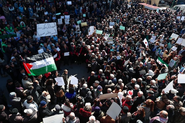 Syrian Druze hold up a placard in Arabic reads "Sweida will not be your poisoned dagger in Syria's back." as stage a demonstration against Israeli incursions into Syrian territory in the southern province of Sweida, Syria, Tuesday, Feb. 25, 2025. (AP Photo/Omar Sanadiki)