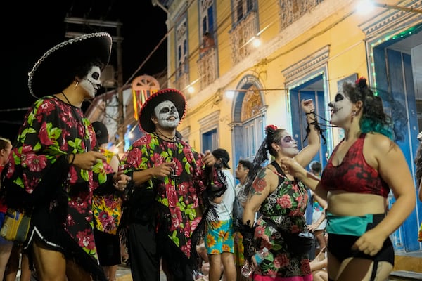 Revelers dance on a street during Carnival in Sao Luiz do Paraitinga, Brazil, Sunday, March 2, 2025. (AP Photo/Andre Penner)