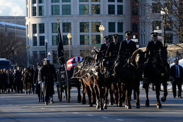 The casket containing the remains of former President Jimmy Carter moves on Constitution Avenue toward the U.S. Capitol on a horse-drawn caisson in Washington, Tuesday, Jan. 7, 2025. Carter died Dec. 29, 2024, at the age of 100. (AP Photo/Susan Walsh, Pool)