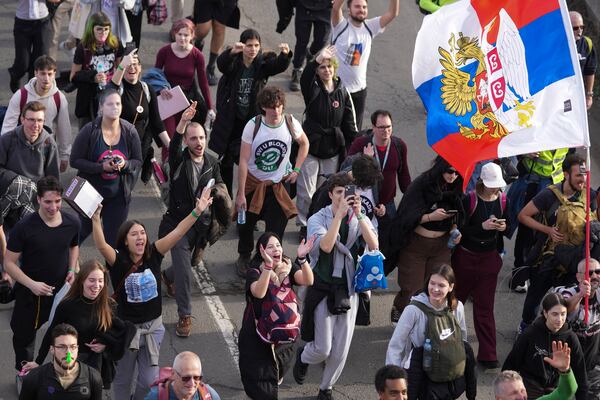 Students walk on the road towards the northern city of Novi Sad, where they will participate in a 24 hour block of three bridges to protest the deaths of 15 people killed in the November collapse of a train station canopy, near the Belgrade suburb of Batajnica, Serbia, Thursday, Jan. 30, 2025. (AP Photo/Darko Vojinovic)