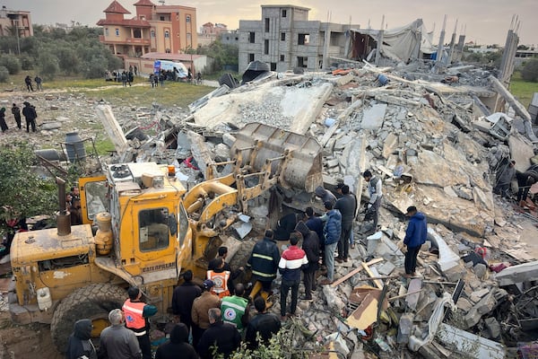 Volunteers and rescue workers use a bulldozer as to remove the rubble of a building hit by an Israeli army airstrike in Khan Younis, southern Gaza Strip, Thursday, March 20, 2025. (AP Photo/Mariam Dagga)