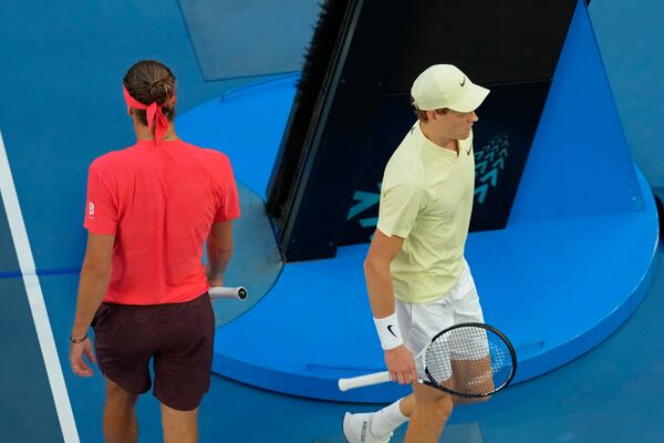 Jannik Sinner of Italy, right, and Alexander Zverev of Germany walk past each other during the men's singles final at the Australian Open tennis championship in Melbourne, Australia, Sunday, Jan. 26, 2025. (AP Photo/Manish Swarup)