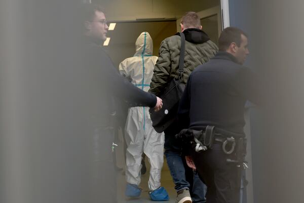 Police officers accompany an arrested suspect, second left, to the magistrate's court in Aschaffenburg, Germany, Thursday, Jan. 23, 2025 following the fatal attack in a park. (Daniel Loeb/dpa via AP)