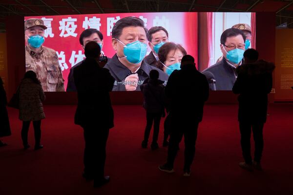 FILE - People attend an exhibition on the city's fight against the coronavirus in Wuhan in central China's Hubei province, Jan. 23, 2021. (AP Photo/Ng Han Guan, File)