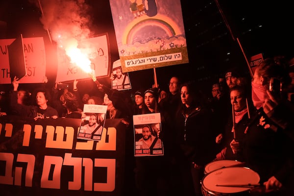 Demonstrators light a flare during a protest demanding the immediate release of hostages held by Hamas in the Gaza Strip, in Tel Aviv, Israel, Saturday, Feb. 22, 2025. (AP Photo/Maya Alleruzzo)