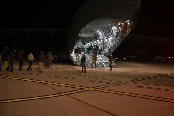 This photo provided by the U.S. Dept. of Defense, U.S. Customs and Border Protection agents guide undocumented immigrants onto a C-17 Globemaster III at the Tucson International Airport, Ariz., Thursday, Jan. 23, 2025. (TSgt Kimberly Nagle/U.S. Dept. of Defense via AP)