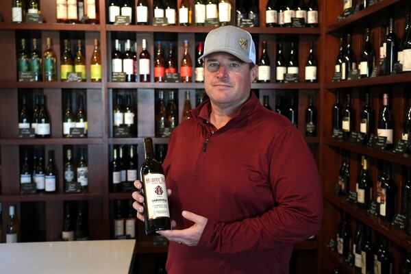 Craig Ledbetter of Vino Farms holds a bottle of wine made with grapes grown in his family-owned vineyards at the Lodi Wine Visitor Center in Lodi, Calif., March 18, 2025. (AP Photo/Terry Chea)