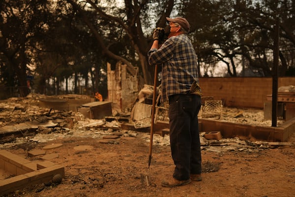 Paul Perri searches through his daughter's fire-ravaged property in the aftermath of the Eaton Fire Thursday, Jan. 9, 2025 in Altadena, Calif. (AP Photo/Eric Thayer)