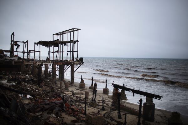 A fire-damaged beachfront property is seen in the Palisades Fire zone during a storm Thursday, Feb. 13, 2025, in Malibu, Calif. (AP Photo/Ethan Swope)