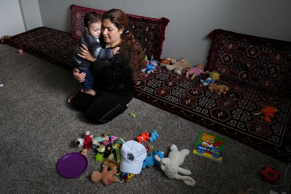 After arriving to the United States from Albania, hours earlier, Noria Sdeqi comforts her tired daughter Sadaf Osmani, 13 months, in their new home in Rancho Cordova, Calif., Wednesday, March 12, 2025. (AP Photo/Rich Pedroncelli)