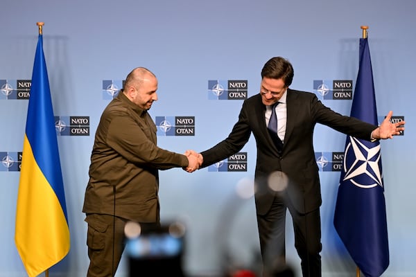 NATO Secretary General Mark Rutte, right, shakes hands with Ukraine's Defense Minister Rustem Umerov address the media during a meeting of NATO defense ministers at NATO headquarters in Brussels, Thursday, Feb. 13, 2025. (AP Photo/Harry Nakos)