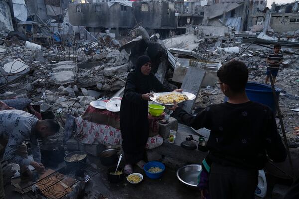 Members of Palestinian Marouf family cook outside their destroyed house by the Israeli army's air and ground offensive in Jabaliya, Gaza Strip, on Monday, March 17, 2025. (AP Photo/Jehad Alshrafi)