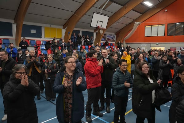 People applaud as the polls open for people to cast their vote in parliamentary elections, in Nuuk, Greenland, Tuesday, March 11, 2025. (AP Photo/Evgeniy Maloletka)