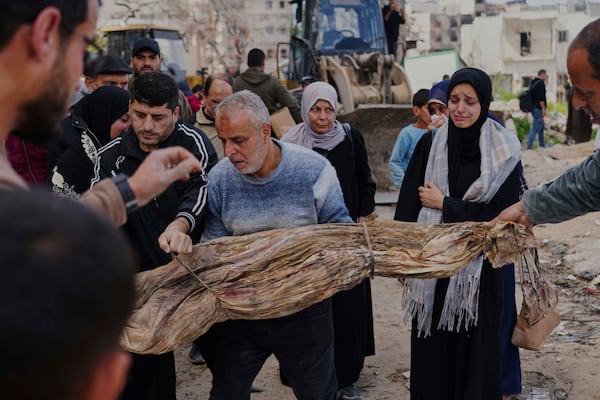 The bodies of Palestinians killed during the Israel-Hamas war and were buried in a mass grave at Shifa Hospital yard are exhumed for identification and reburial in Gaza City's official cemeteries, on Thursday, March 13, 2025. (AP Photo/Abdel Kareem Hana)