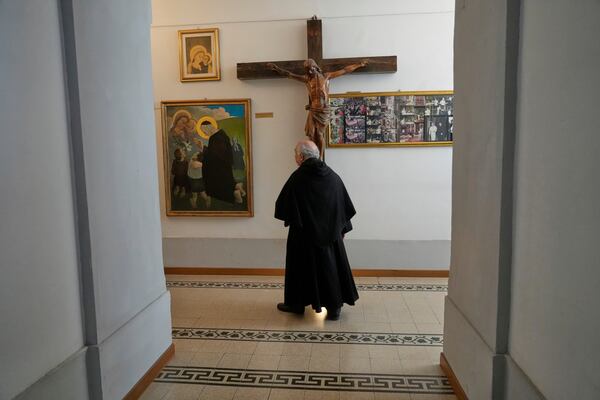 Augustinian friar Paolo Angelone walks by a crucifix in the Sanctuary of Our Mother of Good Counsel during an interview in Genazzano, Italy, Thursday, May 15, 2025. (AP Photo/Gregorio Borgia)