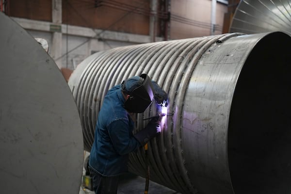 An employee works on a container at a steel tank factory in Mexico City, Tuesday, Feb. 11, 2025. (AP Photo/Eduardo Verdugo)