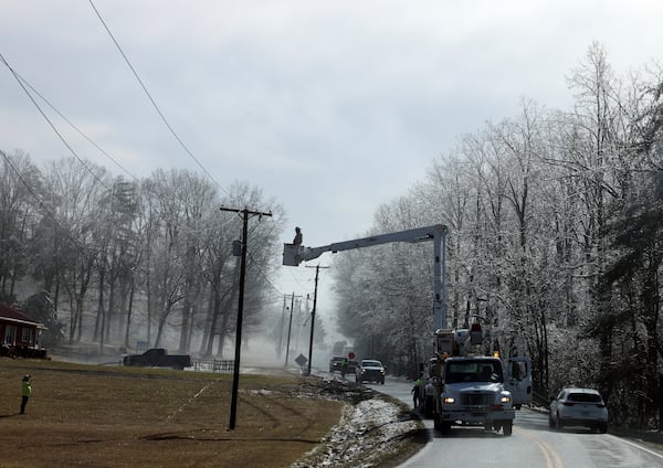 Utility crews work on power lines after a winter storm blanketed the area Thursday, Feb. 13, 2025, in Franklin County, Va. (Heather Rousseau/The Roanoke Times via AP)