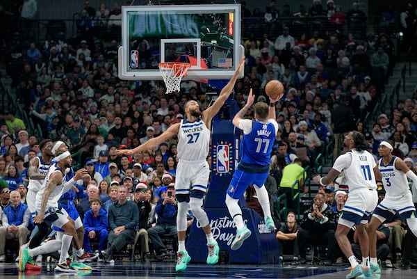 Dallas Mavericks guard Luka Doncic (77) attempts a shot over Minnesota Timberwolves center Rudy Gobert (27) in the first half of an NBA basketball game on Wednesday, Dec. 25, 2024, in Dallas. (AP Photo/Emil T. Lippe)