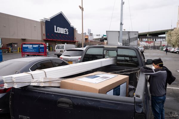 FILE - Lowe's customers wear masks as they load building supplies into their truck, Friday, April 3, 2020, during the coronavirus pandemic in New York. (AP Photo/Mark Lennihan, File)