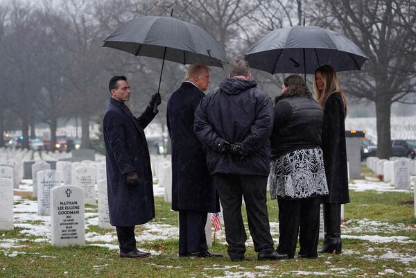 President-elect Donald Trump and Melina Trump talks with family members in Section 60 at Arlington National Cemetery, Sunday, Jan. 19, 2025, in Arlington, Va. (AP Photo/Evan Vucci)