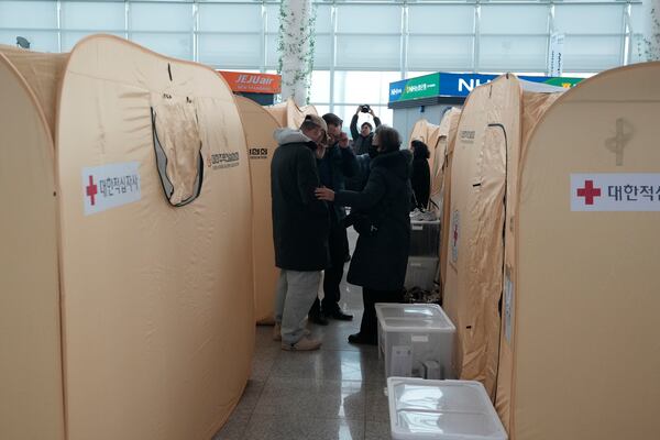 Relatives of the passengers of a plane which burst into flames, react at a temporary shelter at Muan International Airport in Muan, South Korea, Monday, Dec. 30, 2024. (AP Photo/Ahn Young-joon)